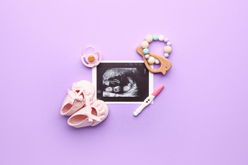Pregnancy test, baby booties, sonogram image, toy and pacifier on color background