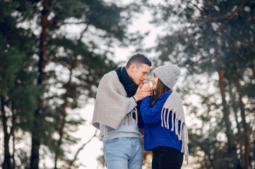 Couple in a winter forest. Beautiful girl in a blue sweater.