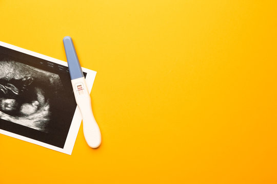 Pregnancy test and sonogram image on color background