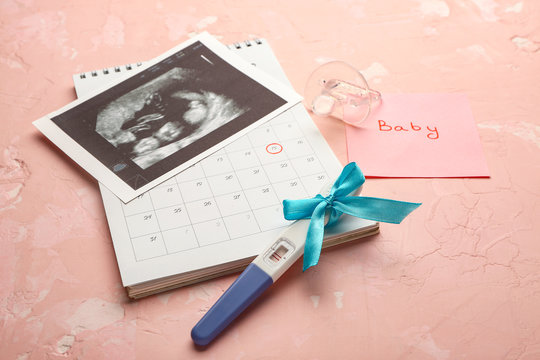 Pregnancy test, sonogram image and calendar on color background