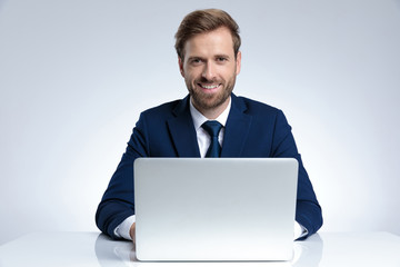 Cheerful businessman laughing while wearing a blue suit