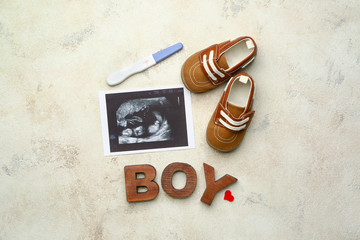 Pregnancy test, sonogram image, baby booties and word BOY on light background