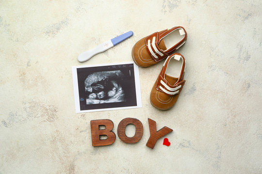 Pregnancy test, sonogram image, baby booties and word BOY on light background