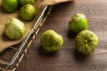 Fresh Picked tomatillos in wire basket on burlap