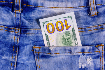 American one hundred dollar banknote in a pocket of blue jeans