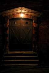 entrance to an old brick building lit by a lamp