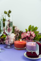 Marriage proposal and love concept for Valentine`s day, box with wedding or engagement ring with brilliant. Glass of champagne, romantic dinner, peony flowers and candles on trendy purple background