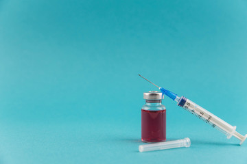 Medicine bottle for injection. Medical glass vials and syringe for vaccination. Liquid red drug or...