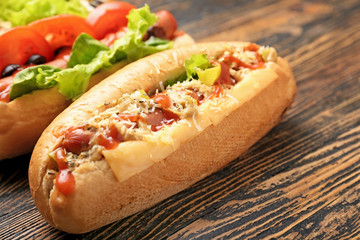 Tasty hot dogs on wooden background