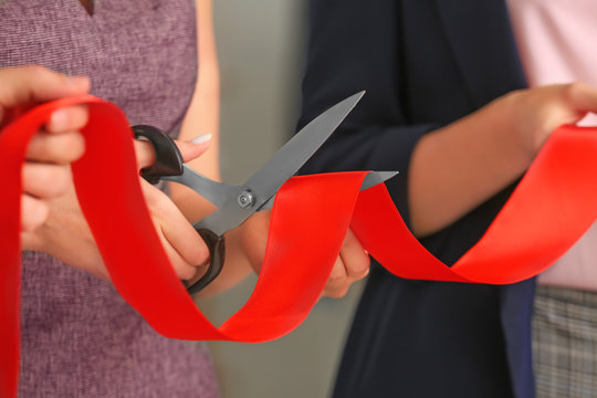 Woman cutting red ribbon at the opening ceremony