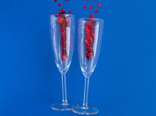Valentines day composition. Flat lay with two champagne glasses with red hearts  on classic blue background. Top view. Valentine day, wedding, birthday concept. Greeting card