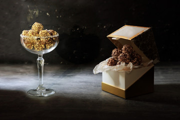 Chocolate truffle. Dark chocolate and cherry candy sprinkled with cocoa on a dark wooden background in rustic style. Atmospheric food photo.