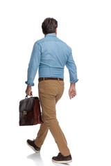 Rear view of a motivated casual man walking
