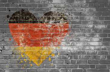 Heart shaped flag of Germany painted on brick wall