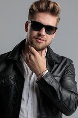 Obraz premium young fashion model in leather jacket touching beard