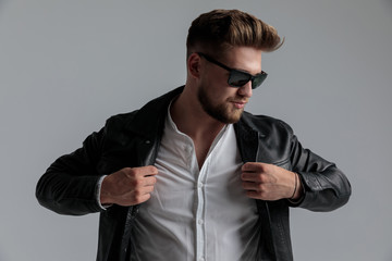 cool dramatic guy wearing leather jacket and sunglasses