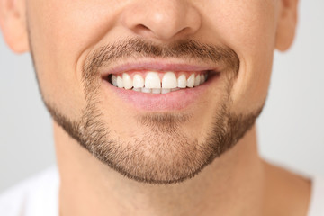 Fototapeta premium Handsome smiling man on light background, closeup