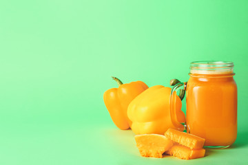 Mason jar of fresh vegetable juice on color background