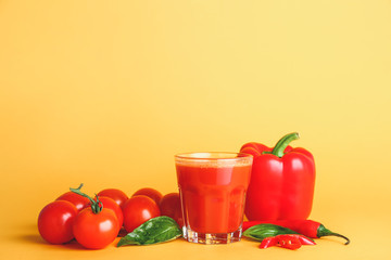 Glass of fresh vegetable juice on color background