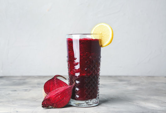 Glass of fresh beet juice on table