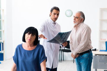 Old couple visiting young male doctor