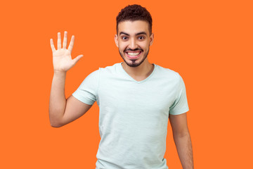 Hello! Portrait of friendly glad handsome brunette man with beard in casual white t-shirt showing...