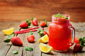 strawberry lemonade with fresh strawberries on a wood background
