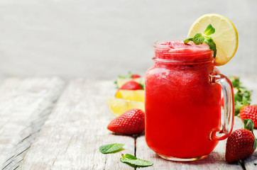 strawberry lemonade with fresh strawberries on a wood background