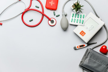 Composition with sphygmomanometer and pills on light background
