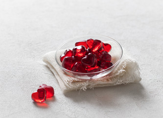 Obraz na płótnie Canvas Jelly marmalade cherry hearts in a saucer on a white background