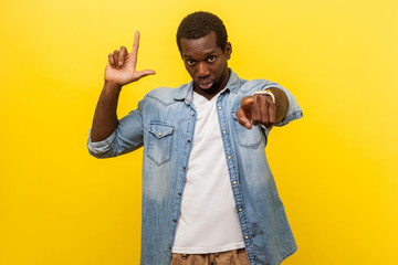 You are loser! Portrait of serious bossy man in denim casual shirt pointing at camera and showing...