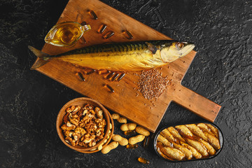 Set of healthy products with high omega 3 and fish oil pills on dark background