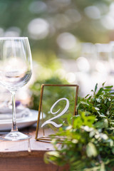 Preparing for an open-air party. Decorated with fresh flowers served tables. Table number. Decoration Details