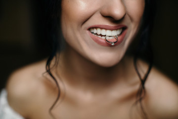 Close up portrait of gorgeous beauty young bride showing her wedding ring holding in teeth and...