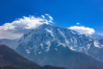 Nepal snowy mountains against the blue sky with clouds