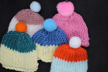 five knitted hats with pompoms