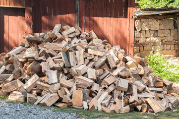 Pile of cut firewood in front of rural country house