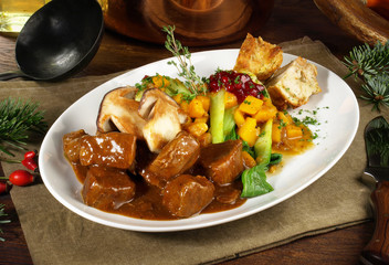 Hirschgulasch mit Steinpilze, Gemüse und Semmelknödel
