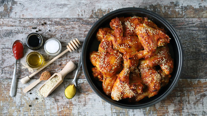 Selective focus. Appetizing buffalo wings in a pan. Baked chicken wings with sesame seeds.