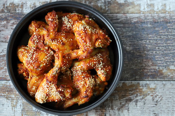 Selective focus. Appetizing buffalo wings in a pan. Baked chicken wings with sesame seeds.