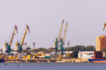 Fototapeta na wymiar Industrial landscape with port cranes in the port on the background of the city view