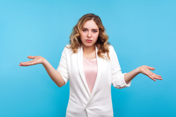 Don't know! Portrait of confused clueless woman with wavy hair in white jacket raised hands in bewilderment, questioning gesture, looking helpless embarrassed, no idea sign. indoor studio shot