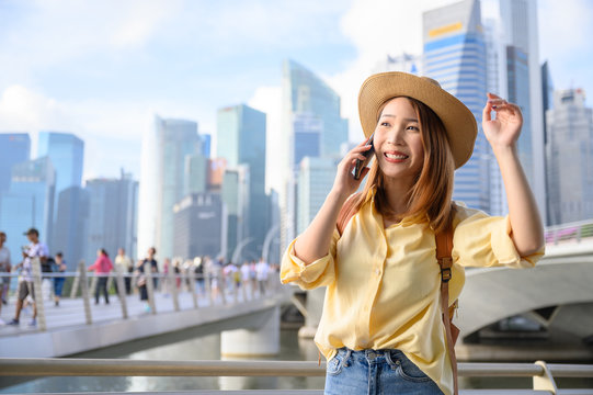 Young Woman In Calling On Phone With Friend During Travel In Singapore