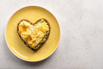 heart shaped healthy avocado toast with scrambled egg
