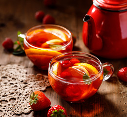Fruit hot tea with the addition of oranges, lemons, strawberries mandarins and raspberries in a...