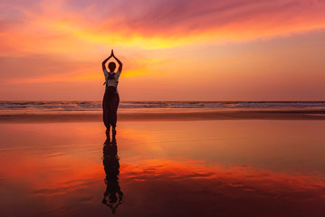 Beautiful yoga meditation reflection on water Goa beach on sunset - obrazy, fototapety, plakaty