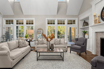 Beautiful living room in new traditional style luxury home. Features vaulted ceilings, fireplace and elegant furnishings.