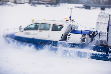 View of rescue team Hovercraft. hover craft transport boat crossing frozen river lake on the ice in the winter snowy day