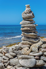 Piled stones on coast with blue sea
