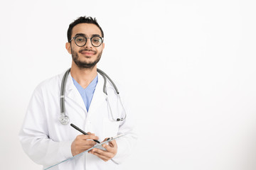 Successful clinician in eyeglasses and whitecoat making medical prescriptions